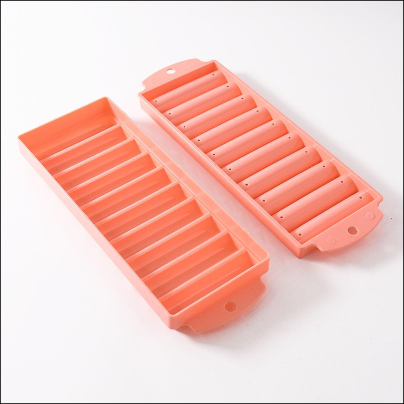 Pink compact ice stick tray with two separate molds for making long ice sticks