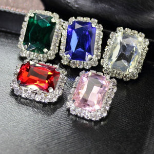 Colorful interchangeable diamond earrings featuring green, blue, red, clear, and pink gemstones