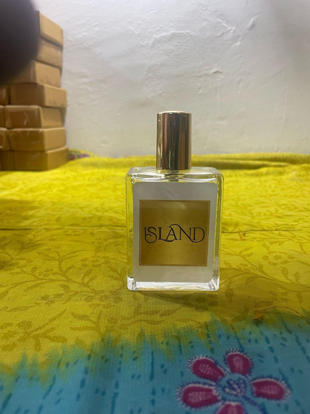 Island perfume 50ml in a clear bottle with a gold cap on a colorful background