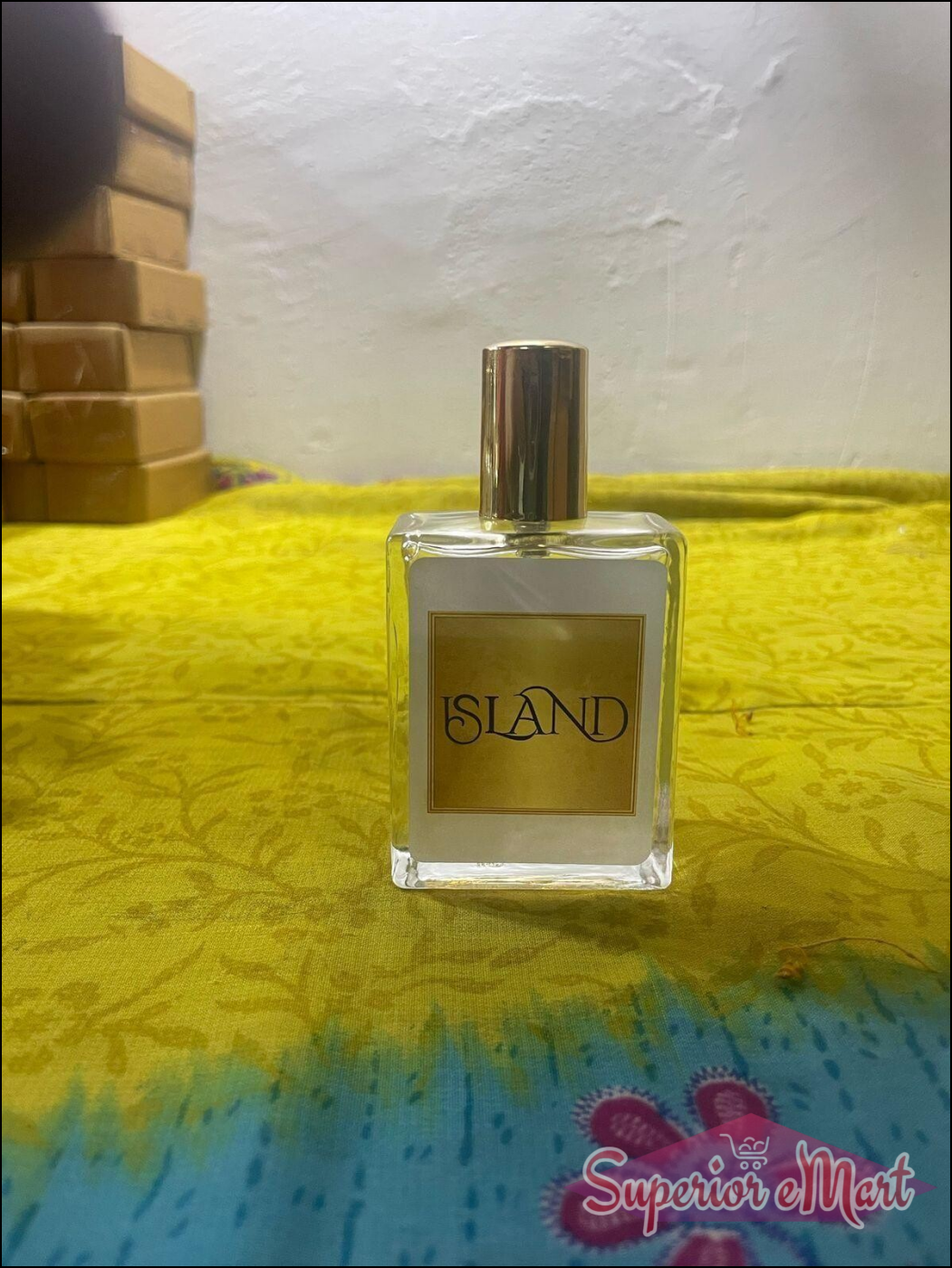 Island perfume 50ml in a clear bottle with a gold cap on a colorful background