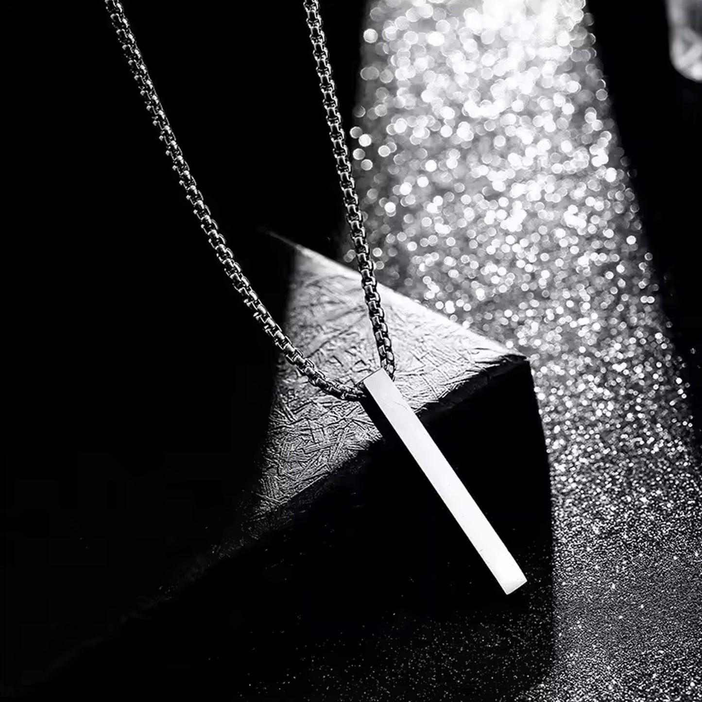 Elegant stainless steel locket necklace on a textured background with a sleek design