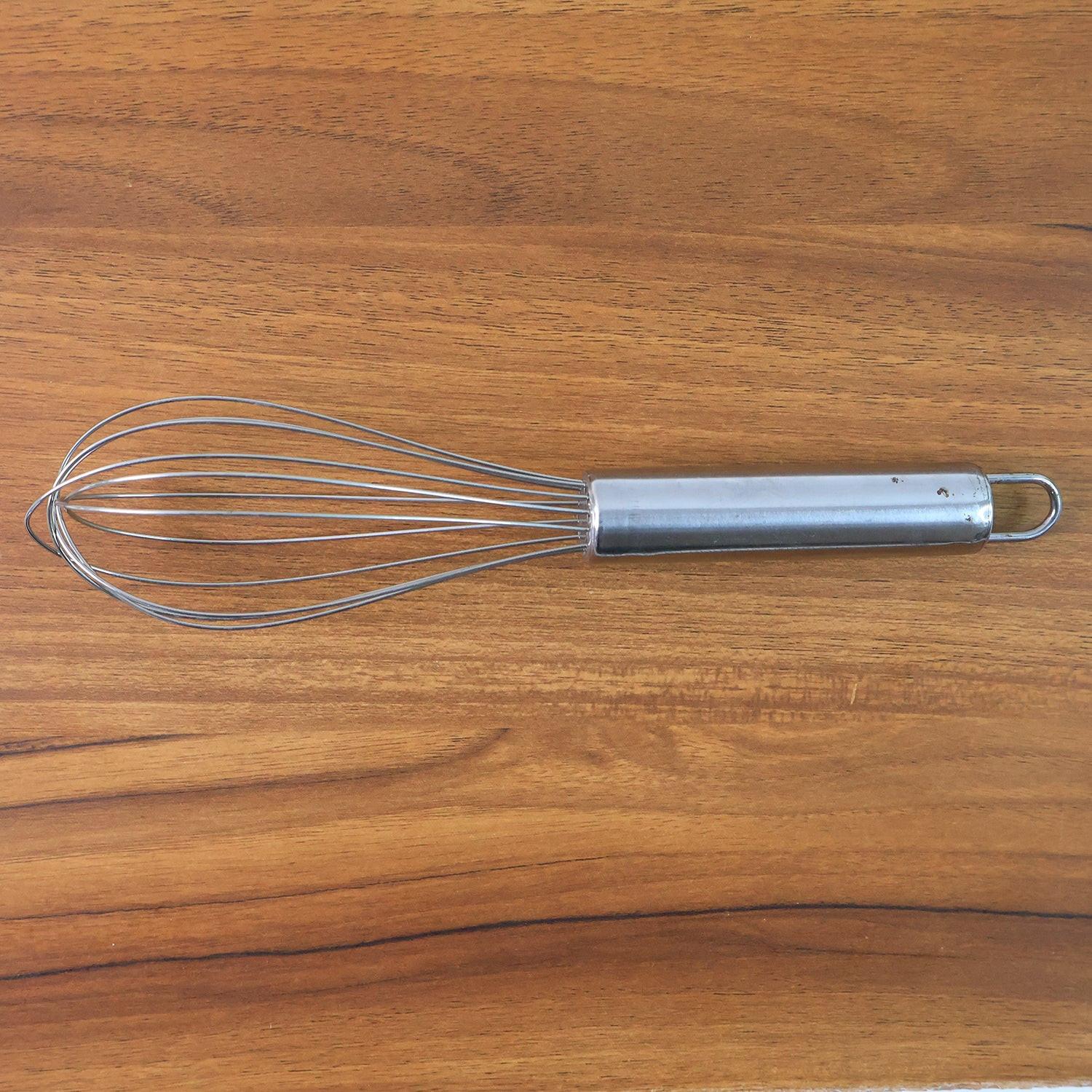 Small stainless steel balloon whisk with a sleek handle, ideal for beatings eggs and mixing ingredients