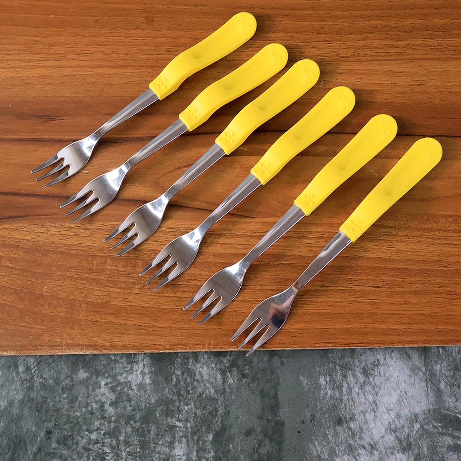 Stainless steel big fork set with yellow handled forks on wooden surface for dining and serving