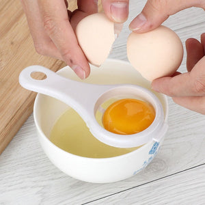 Hands using an egg yolk separator kitchen tool over a bowl to separate yolk from egg white