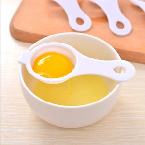 Egg yolk separator kitchen tool in use, separating yolk from egg white in a bowl