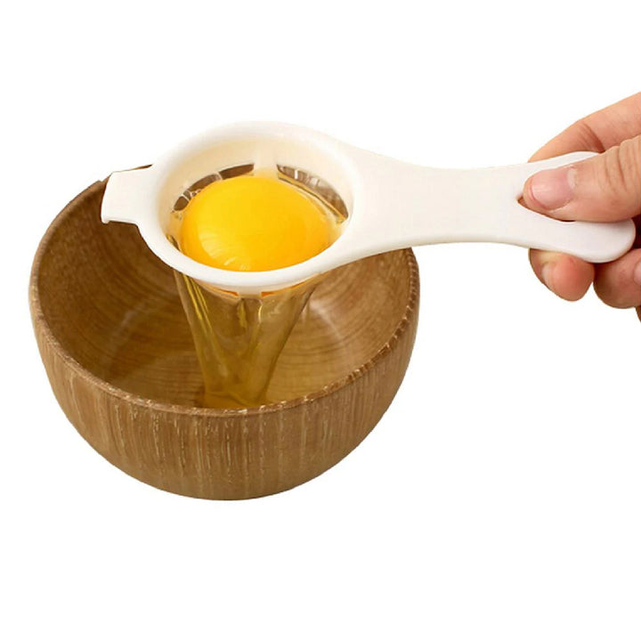 Egg yolk separator kitchen tool in use, effortlessly separating yolk from egg white over a wooden bowl