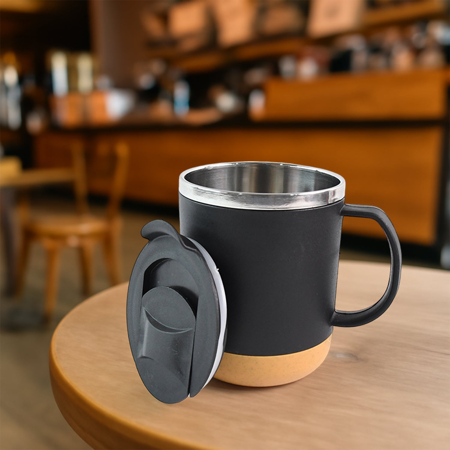 Superior eMart insulated coffee mug with black body and tan base on wooden table in cafe