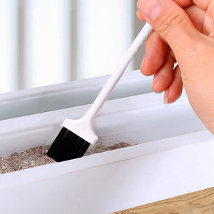 Hand holding a laptop keyboard brush designed for cleaning dust and debris from laptop keyboards