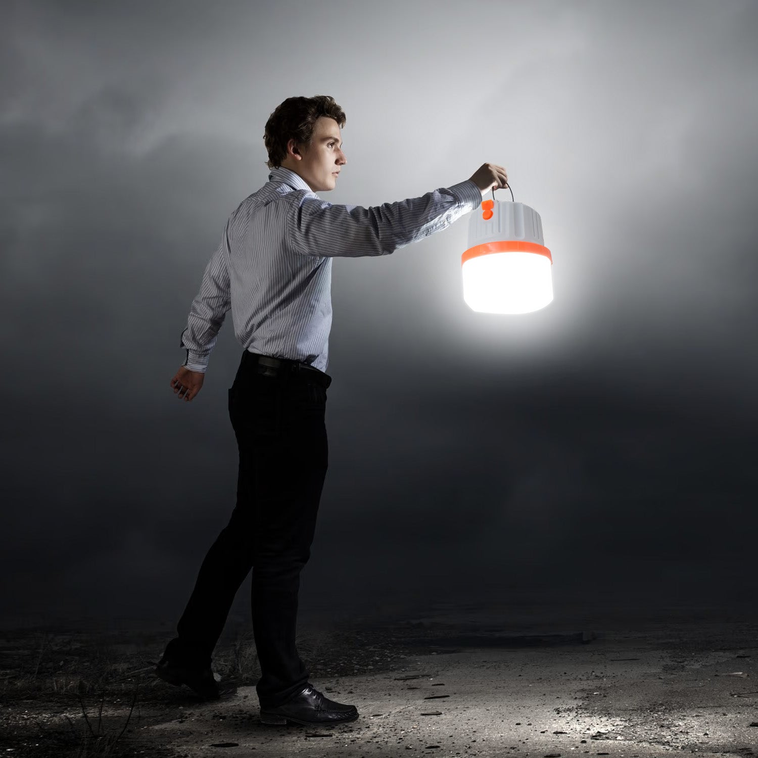 Man holding an LED camping light in a dark landscape, ideal for outdoor adventures