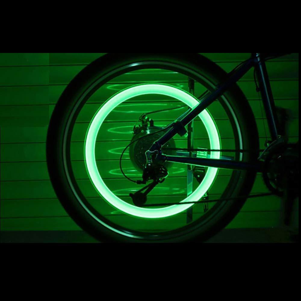 Green illuminated bike wheel featuring LED tire valve caps for enhanced visibility at night