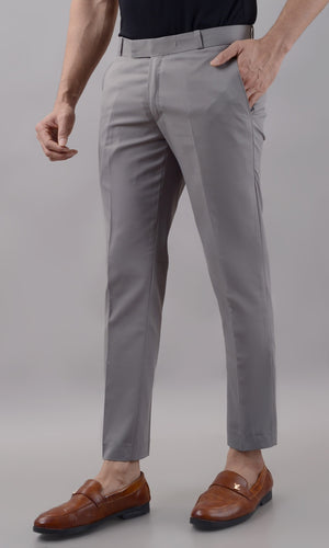 Person wearing gray dress pants with a plain background