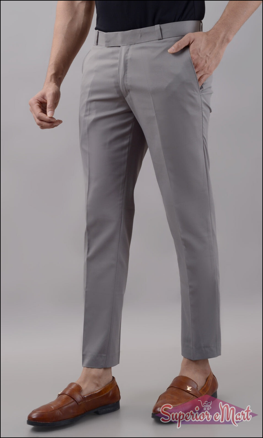 Person wearing gray dress pants with a plain background