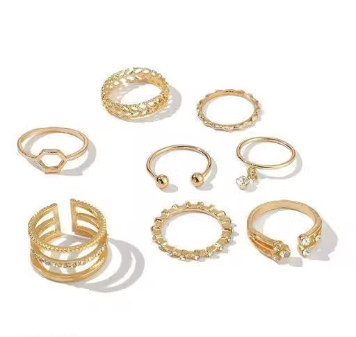 Set of gold rings with various designs on a white background