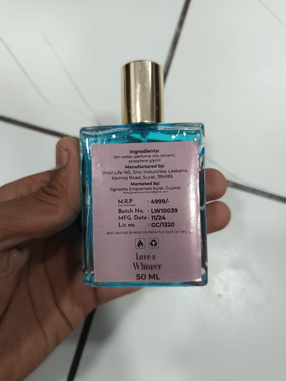 Love's Whisper perfume 100 ml pack of 2 blue bottle with gold cap and ingredient label held in hand