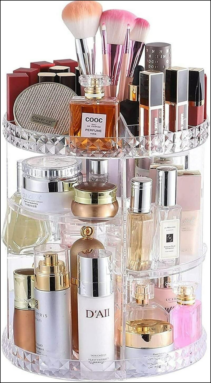 360 rotating clear acrylic makeup organizer with diamond trim, holding brushes, COOC perfume, and skincare bottles.