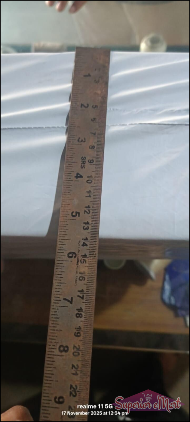 Weathered brown wooden ruler with SRS branding measures a white package. Shows inch and centimeter markings.