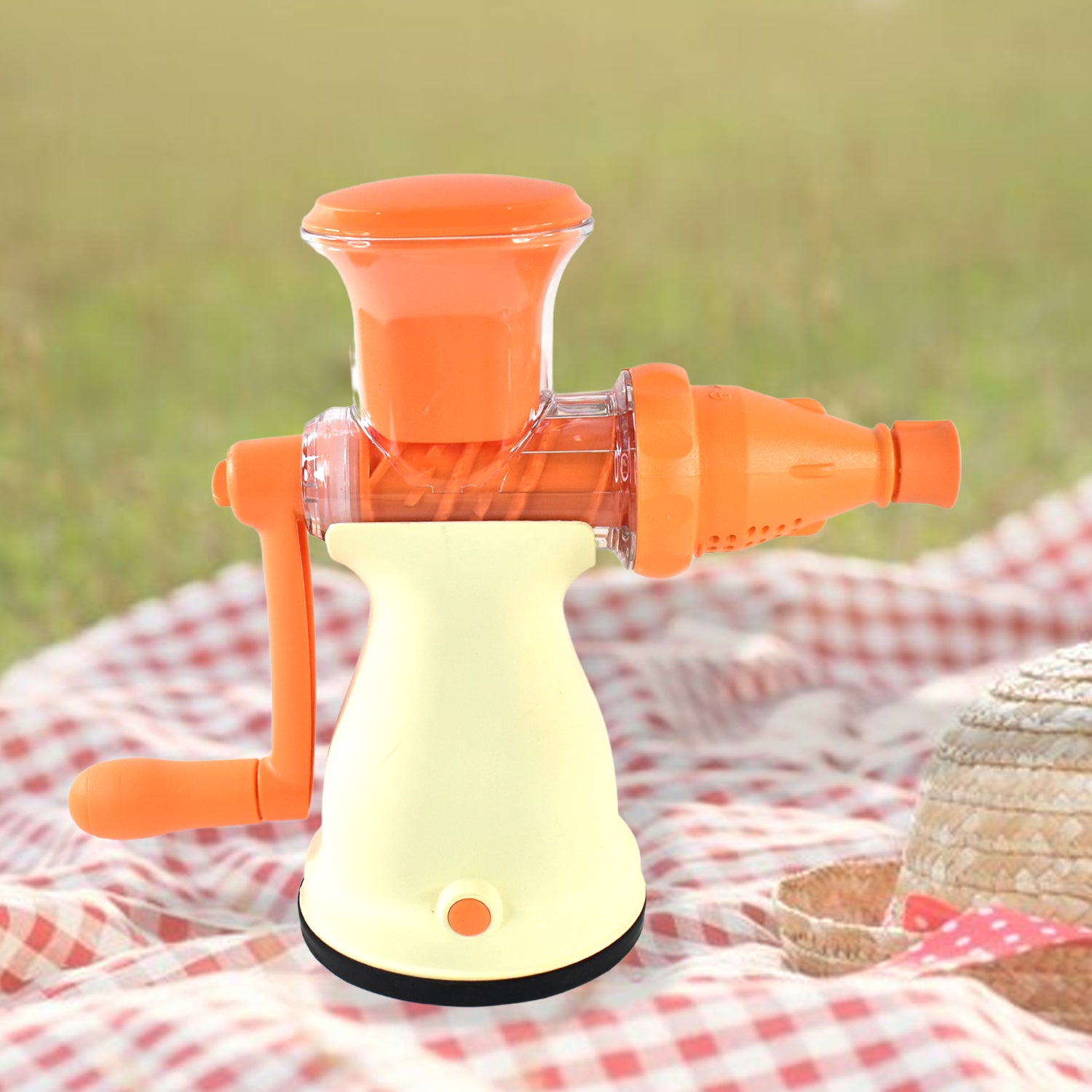 Superior eMart manual fruit juicer for home with orange handle and white base on picnic blanket