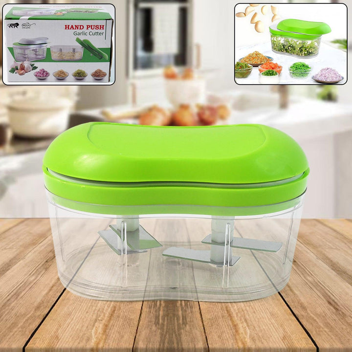 Manual garlic chopper with a green lid for easy herb and garlic chopping in the kitchen