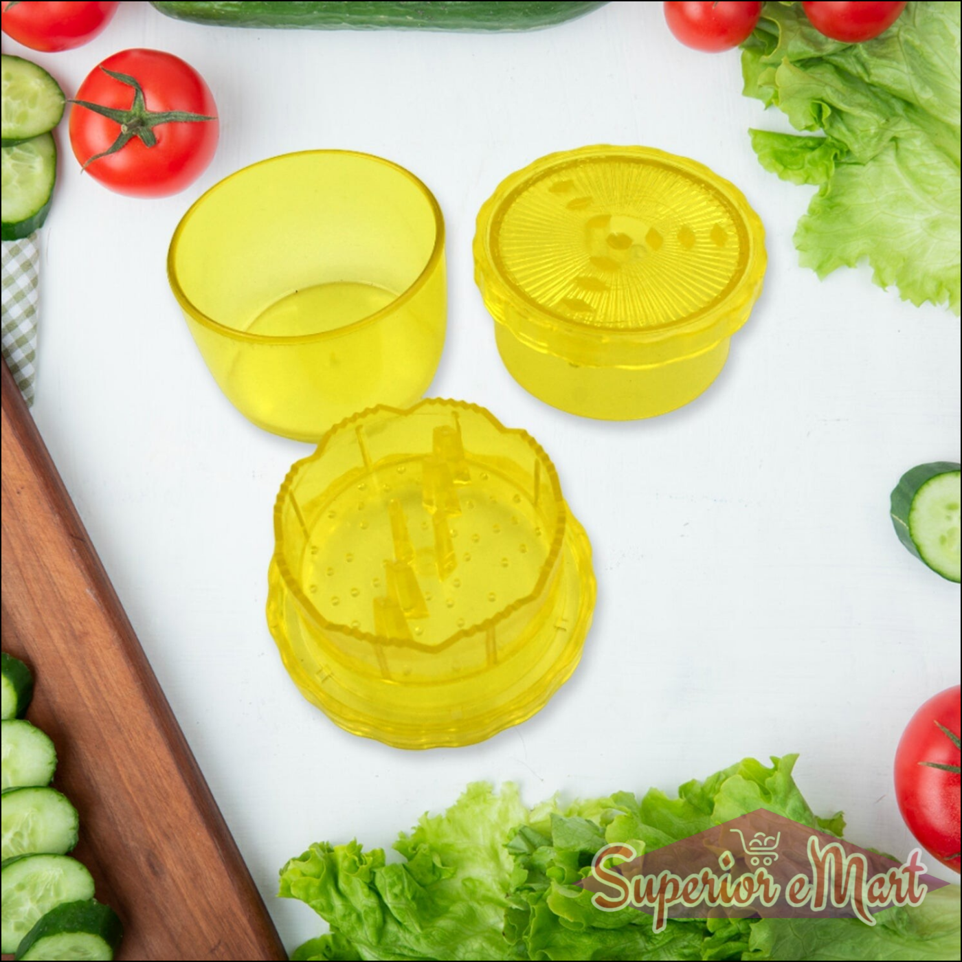Bright yellow manual citrus juicer and grinder with two separate containers and fresh vegetables in the background