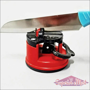 Manual kitchen knife sharpener in red with a knife positioned for easy sharpening