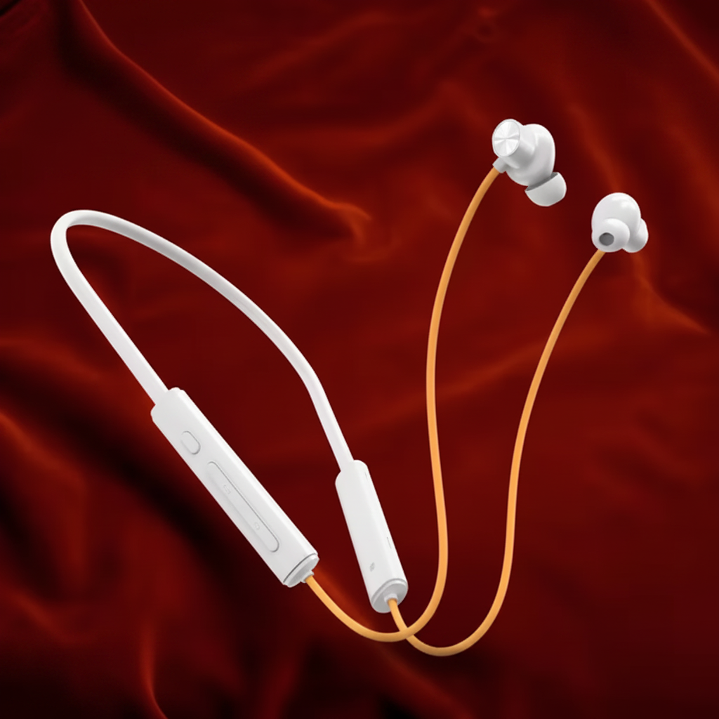 White wireless earbuds with a cable on a red fabric background