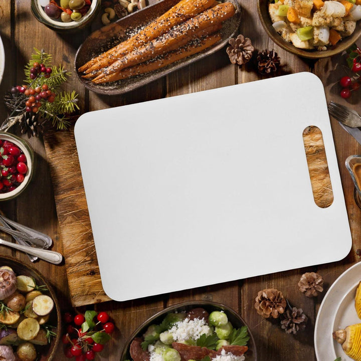 White medium chopping board on a rustic table surrounded by various dishes and garnishes