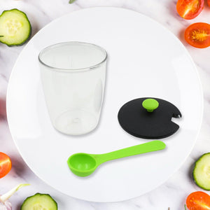 Revolving spice rack set with clear container, black lid, and green measuring spoon for organized kitchen storage