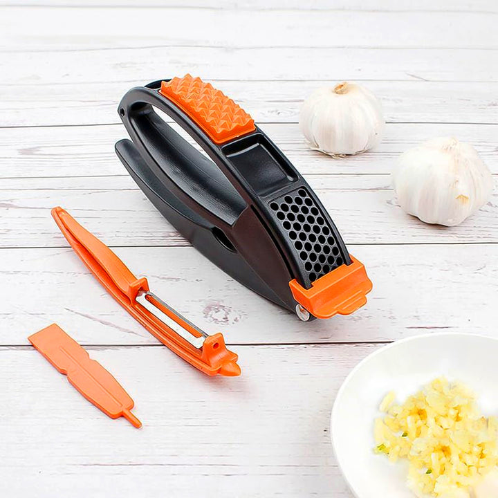 Superior eMart multifunctional garlic press with black and orange handles and garlic cloves on white wooden background
