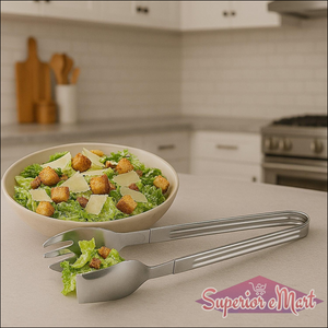 2-in-1 stainless steel serving tong set with salad in a bowl on a kitchen countertop