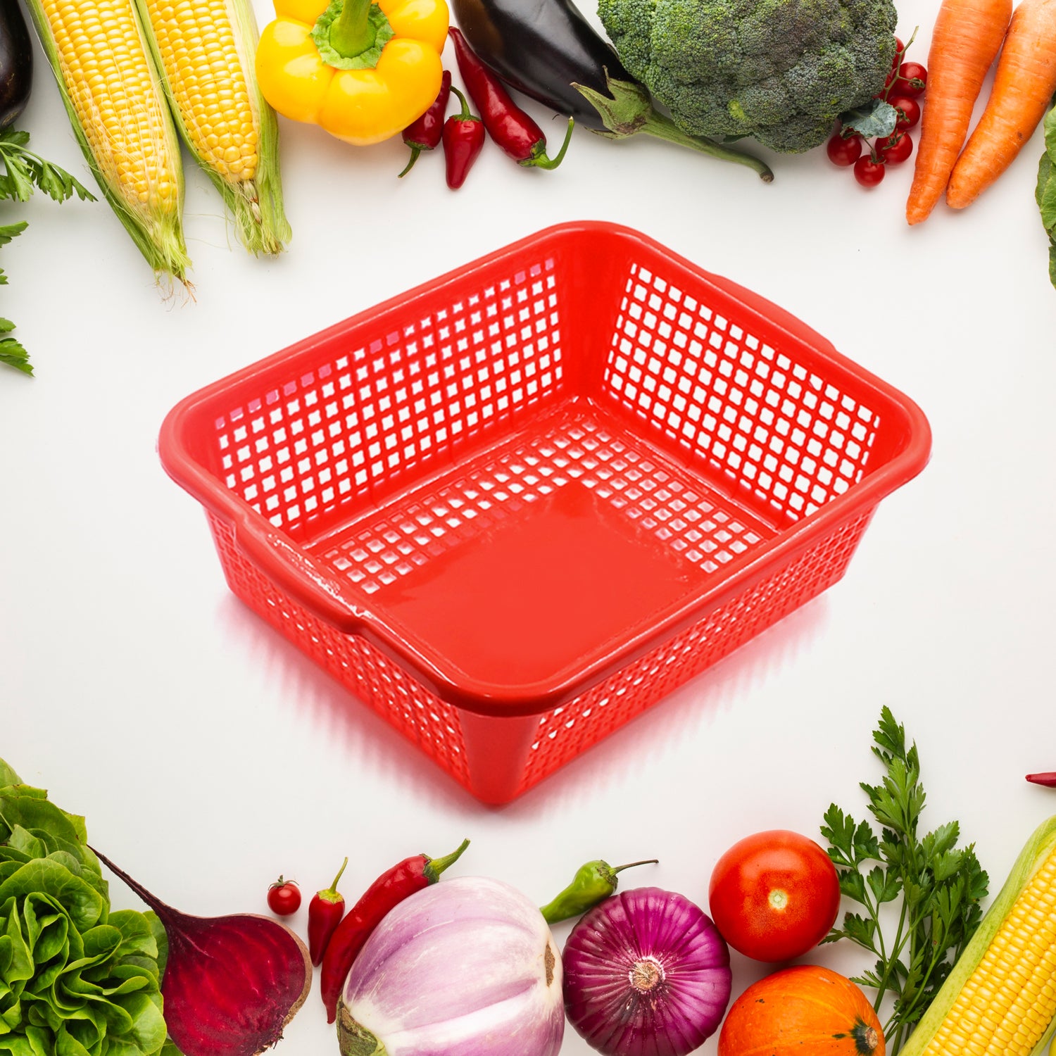 Red multipurpose drain basket for kitchen sink surrounded by fresh vegetables and fruits