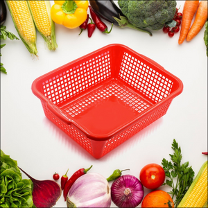 Red multipurpose drain basket for kitchen sink surrounded by fresh vegetables and fruits