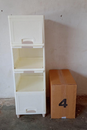 White multipurpose storage cabinet with drawers next to a cardboard box for versatile home organization