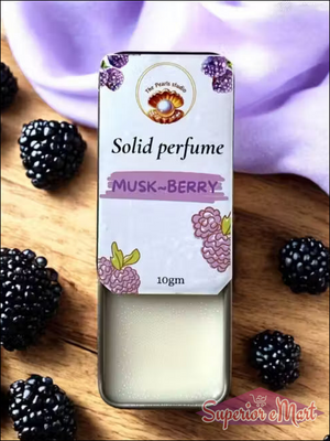 The Pearls studio 10g Musk-Berry solid perfume in an open silver tin, shown with cream balm and fresh blackberries.