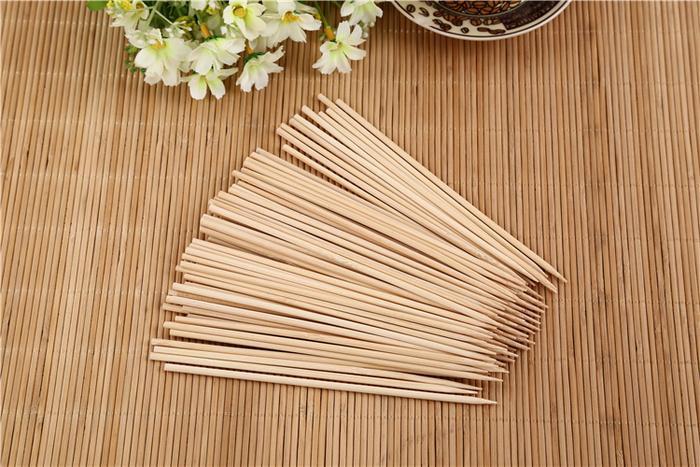Pack of natural bamboo skewers on a wooden surface, ideal for grilling and cooking.