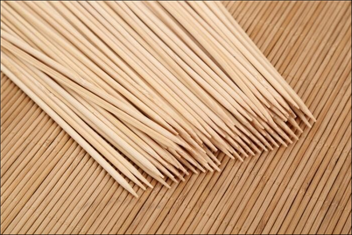 Natural bamboo skewers in a bundle on a textured surface for grilling and cooking
