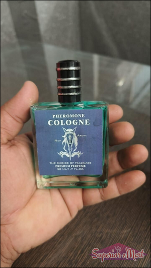 Men's pheromone cologne in a stylish bottle held in a hand for attracting confidence and charisma