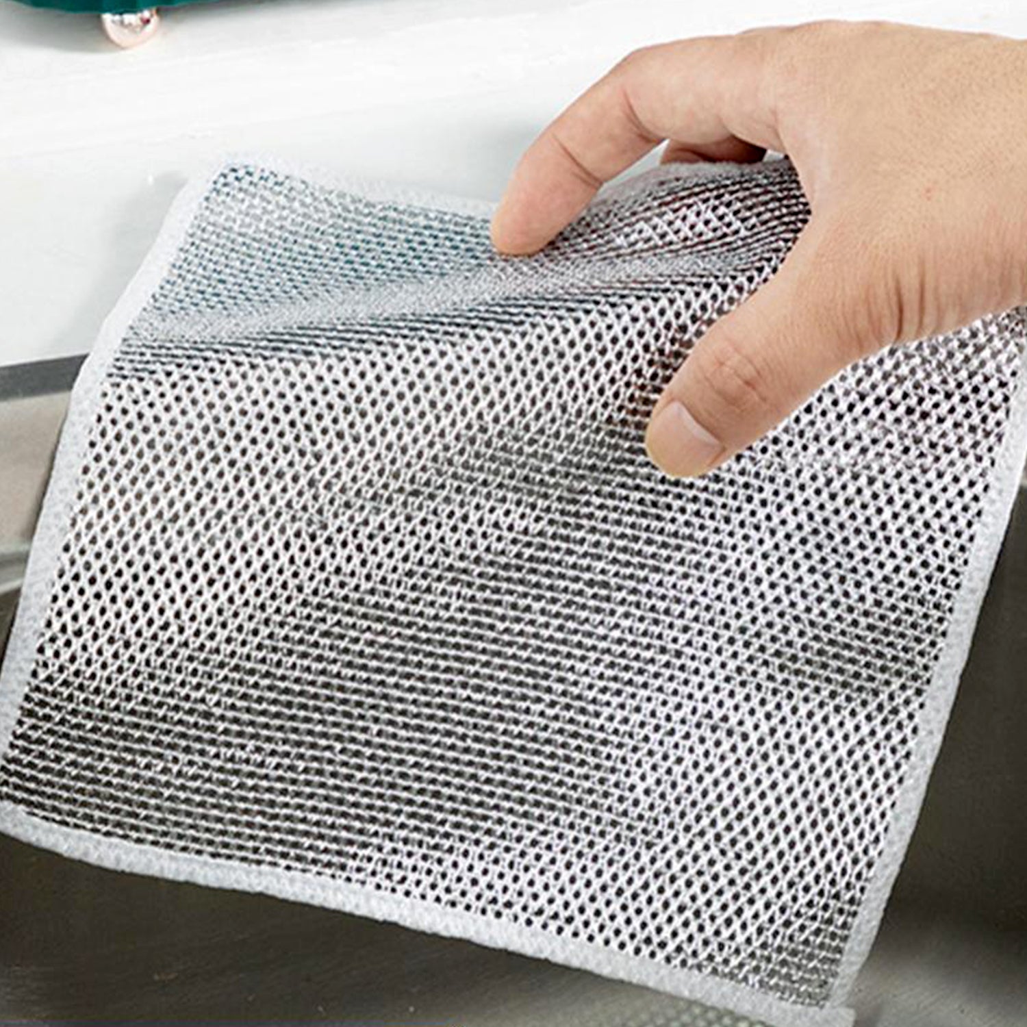 Non-scratch stainless steel scrubber being held for efficient kitchen cleaning without damaging surfaces