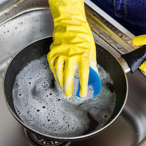 Nylon scrubbers pack of 12 being used to clean a greasy pan with soapy water