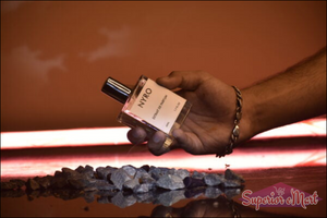 Nyro perfume bottle held above dark stones, showcasing the scent Dark Edge with a bold design
