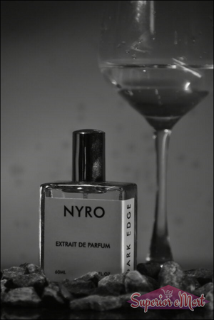 Nyro Extrait de Parfum bottle with dark edge design and stones, set with a glass in the background