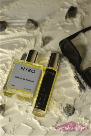Nyro Kyro Extrait de Parfum in two bottle sizes on a textured surface with sunglasses