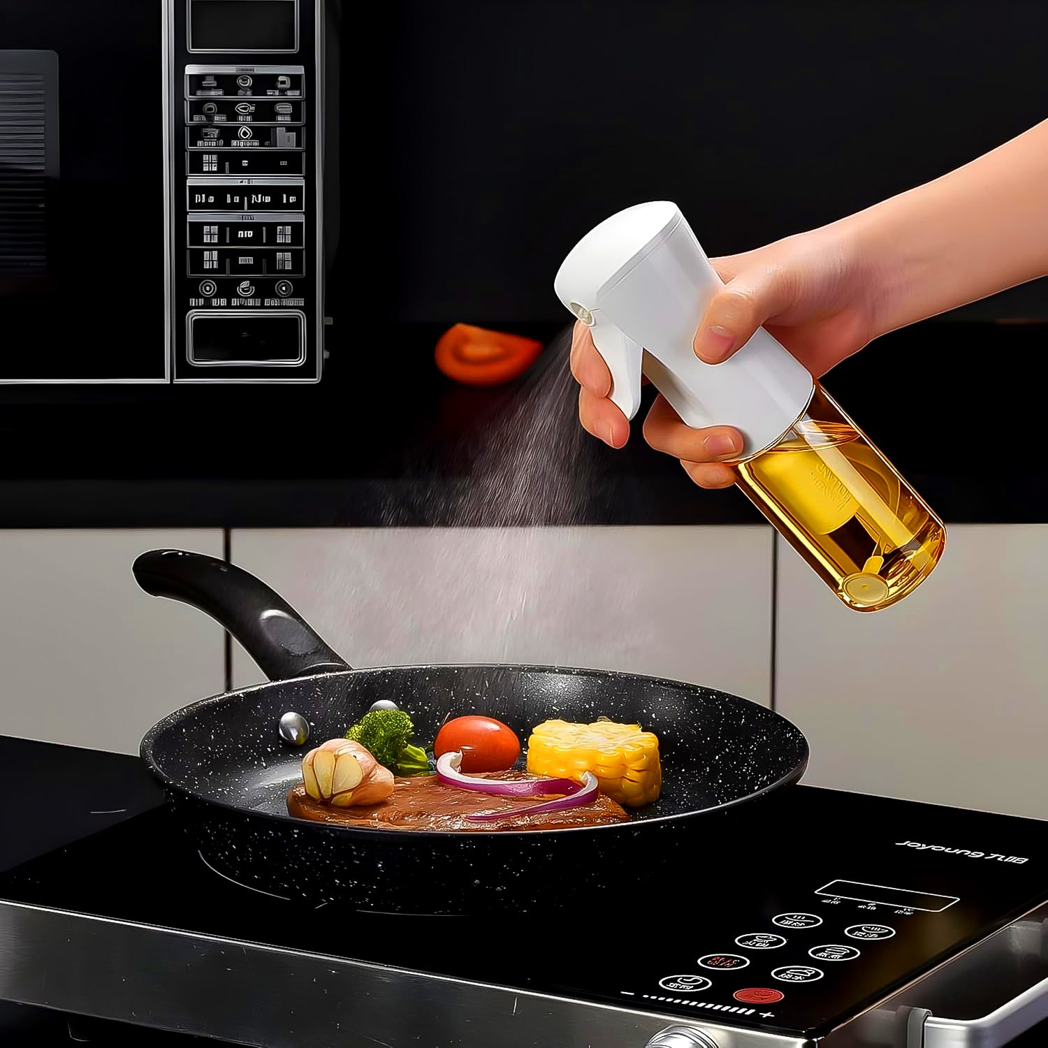 Person using an oil spray bottle for cooking on a frying pan with vegetables and meat