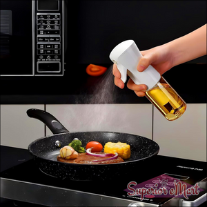 Person using an oil spray bottle for cooking on a frying pan with vegetables and meat