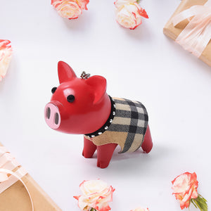 Adorable pig charm accessory with a plaid sweater, perfect for home decor lovers