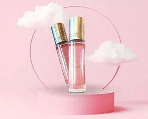 Two bottles of pink love perfume for women on a pastel pink background with fluffy clouds