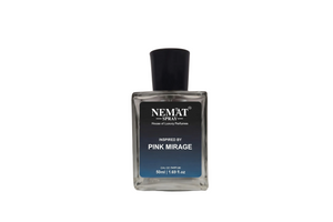 A rectangular glass bottle of NEMAT SPRAY perfume with a black cap and a black-to-blue gradient label, displayed on a black pedestal against a warm beige background.