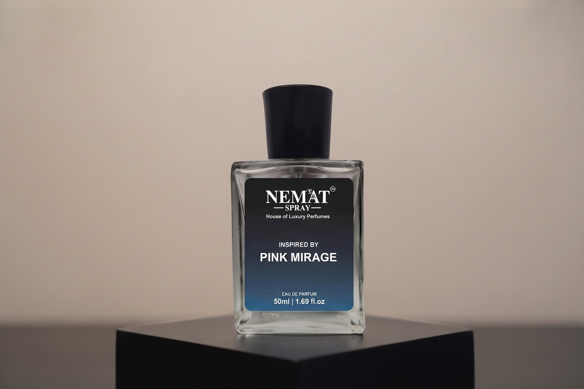 A rectangular glass perfume bottle with a black cap and a black-to-blue gradient label reading 'NEMAT SPRAY' and 'Inspired by Pink Mirage', displayed on a black pedestal against a warm beige background.