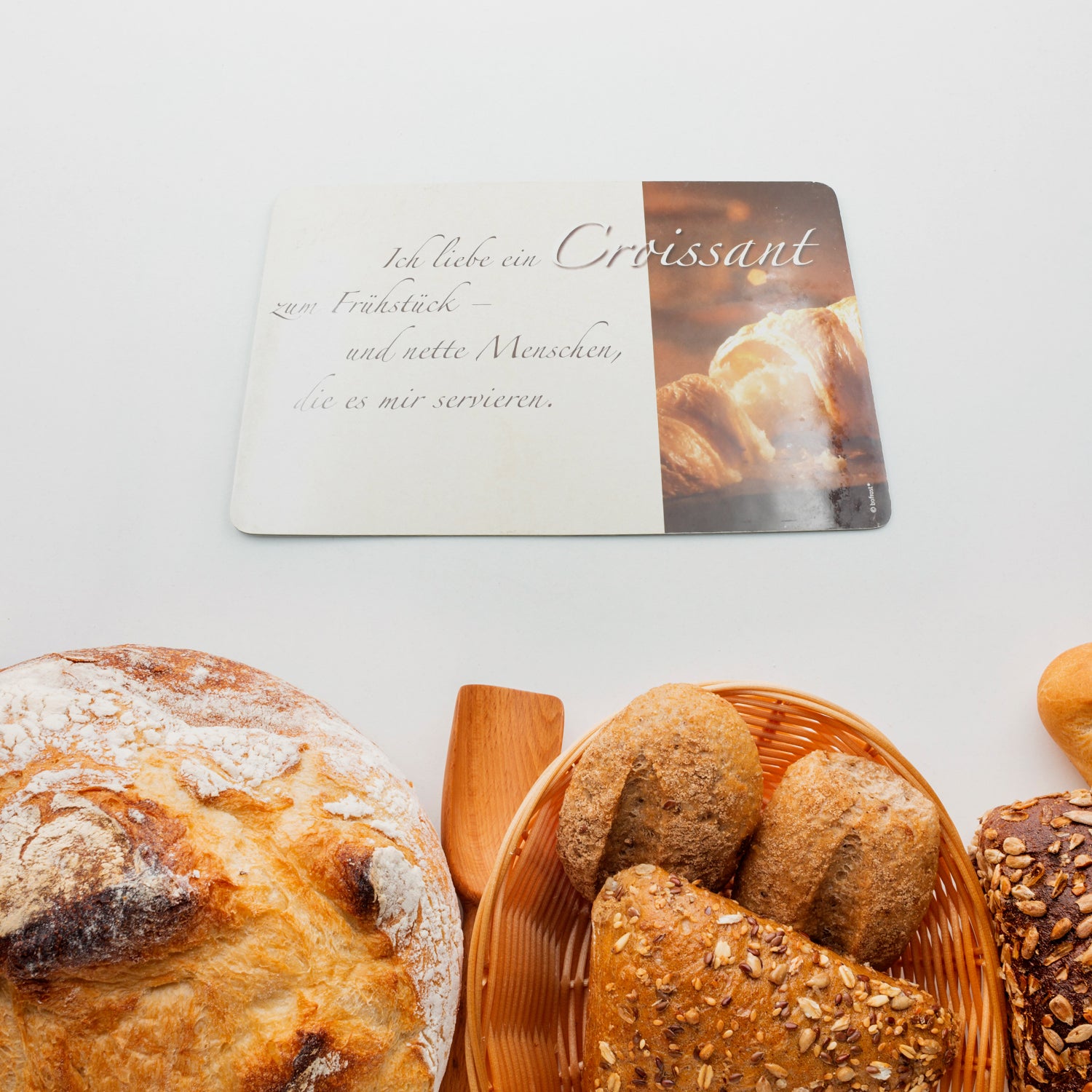 Superior eMart plastic kitchen chopping board shown with freshly baked bread and croissants