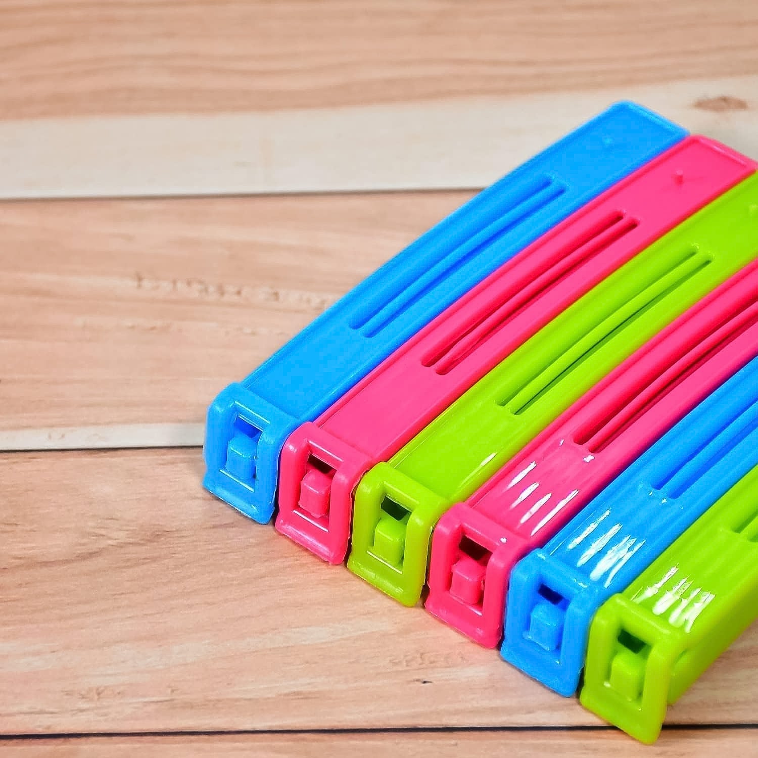 Colorful plastic pouch sealer clips in pink, blue, and green for sealing food bags securely