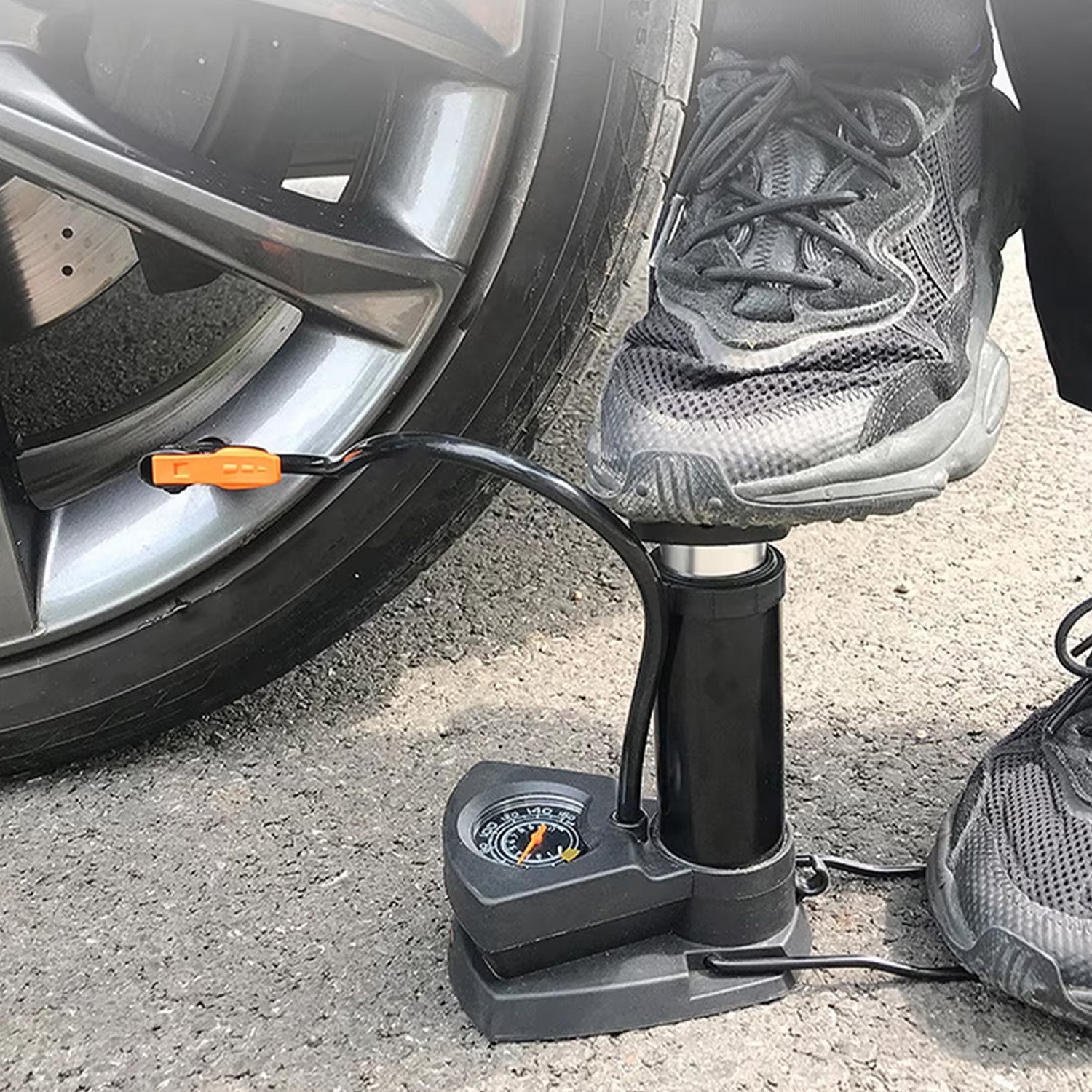 User operating a portable mini bike pump with pressure gauge for easy inflation of tires